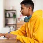 un lycéen faisant ses devoirs à la maison sur son bureau